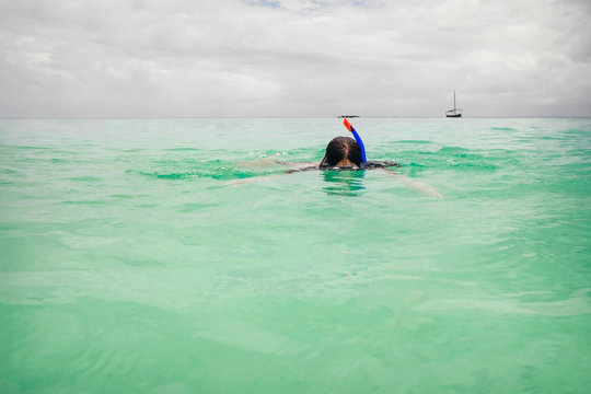 Woman wearing mask for snorkeling in the turquoise ocean