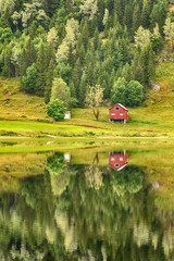 beautiful mountain houses and lakes in Norway with reflection