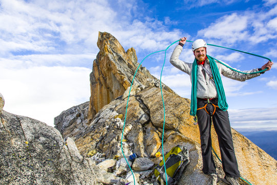 Man coiling a climbing rope at the summit of L'Esfinge, Paron Valley, Caraz, Huaraz, Ancash, Cordillera Blanca, Peru