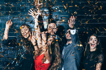 Young beautiful people dancing in confetti. - obrazy, fototapety, plakaty