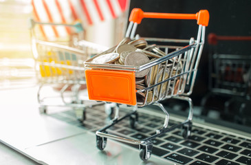 Stack of Thai coins in trolley on laptop keyboard. Idea of exchange money online shopping, Online shopping is form of e-commerce, consumers to buy goods from directly seller through internet.