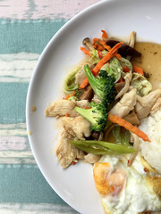 stir-fried vegetables with thai jasmine rice and fried egg in white dish as food for people who need control fat.
