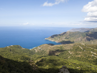 Fototapeta na wymiar Vista aerea della costa della Corsica, strade serpeggianti e calette con mare cristallino. Penisola di Cap Corse, Corsica. Tratto di costa. Anse d'Aliso. Golfo d’Aliso. Francia