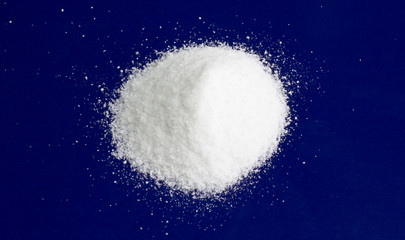 Fototapeta na wymiar Salt. White table salt on a blue background.