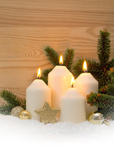 Christmas decoration and four burning Advent candles.