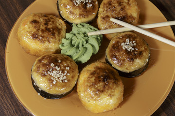 Sushi and rolls isolated on an orange dish. Japanese seafood