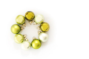 Green Christmas balls in a circle isolated with shadows on a white background, greeting card, flat top view from above, copy space