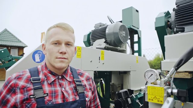 The worker standing near the machine