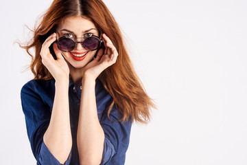 Naklejka premium Beautiful young woman holds on white isolated background in sunglasses