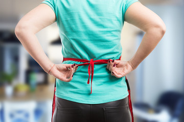 Woman tie a back knot of red apron
