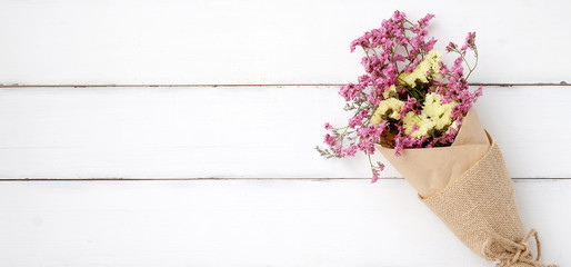 Wild flower bouquet on vintage white wood background with empty space for text