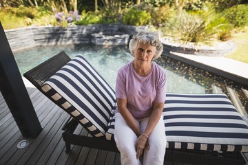 Portrait of serious senior woman sitting on lounge chair