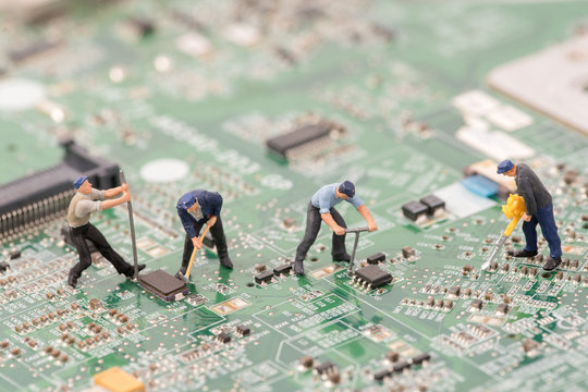 miniature people repair cpu board,teamwork and technology concept