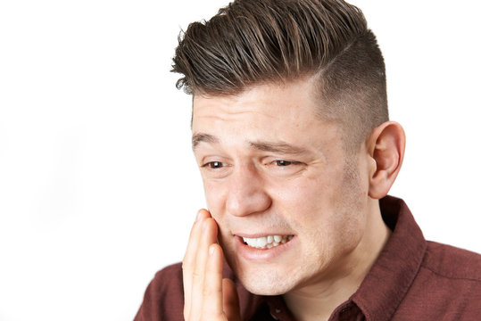 Studio Shot Of Young Man Suffering With Toothache