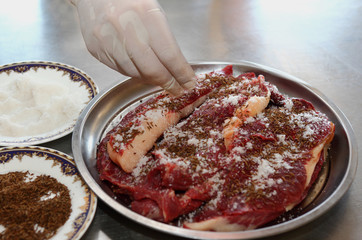 A cook sprinkles salt and condiments meat horse meat for making sausage-Kazi.Uzbek cuisine.