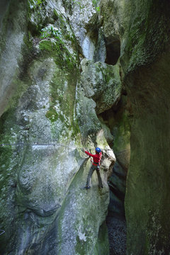 Woman rock climbing in canyon of Sallagoni, Sentiero Rio Sallagoni, Lake Garda range, Trentino, Italy