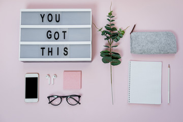 Motivational board, phone and stationery on pink table. Business concept. Top view, flat lay