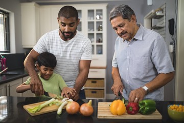 Multi-generation family preparing food in kitchen