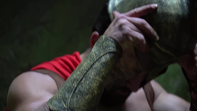 Cropped close up of a strong powerful warrior with ripped muscular torso wearing his helmet preparing for the battle armor protection safety danger courage concept.