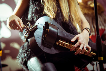 Young girl performs in a club on stage plays on a lyre