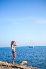 Young girl on blue sea background. Tropical country. Yacht on the background