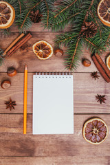 Christmas greeting card and food decor on wooden table with fir tree. Top view with copy space