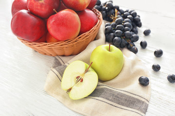 Composition with apples and grapes on wooden table