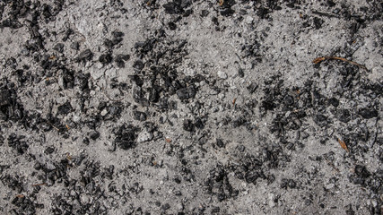The ashes of a fire, just burnt embers spread out in the light