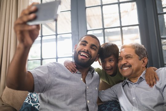 Smiling multi-generation family making face while taking selfie