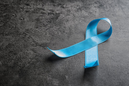 Blue ribbon on grey background. Cancer awareness concept
