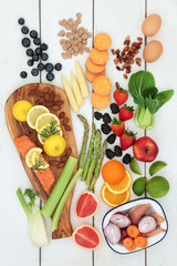 Health food for dieting concept with fresh salmon, fruit, vegetables, dairy, nuts and cereals.  Super foods high in  anthocyanins, antioxidants, fibre and vitamins. Top view on rustic wood background.