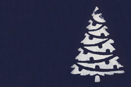 One White Christmas Tree Painted With Paint Through A Stencil On A Dark Blue Background. Copy Space.