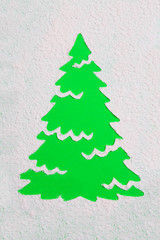 A trace from a stencil in the shape of a Christmas tree made of flour on a green background. Ideas for festive baking and decorating.