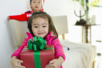Cute girl holding gift boxes and smiling brightly.