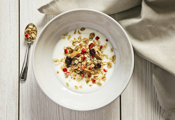 Prima colazione: yogurt con frutta secca e muesli servito in una scodella. Vista dall'alto. Alimentazione sana