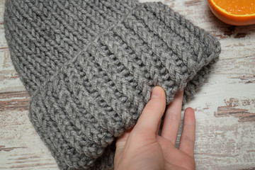 Gray hat in female hand. Winter concept.