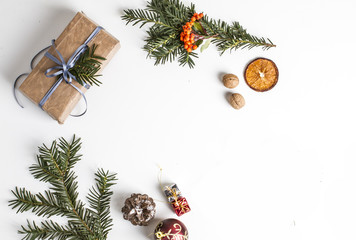 TOP VIEW OF PRESENT BOX WITH FIR BRANCH, PINE CONE AND BAUBLE. CHRISTMAS COMPOSITION ON WHITE BACKGROUND