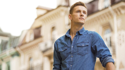 Handsome young man waiting for date, cute smiling guy looking into distance