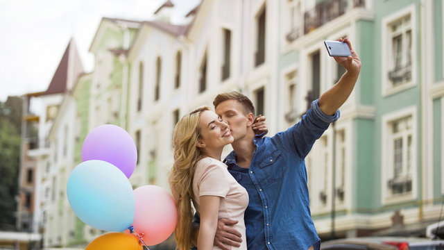 Young couple in love kissing and taking selfie, romantic memories, happiness