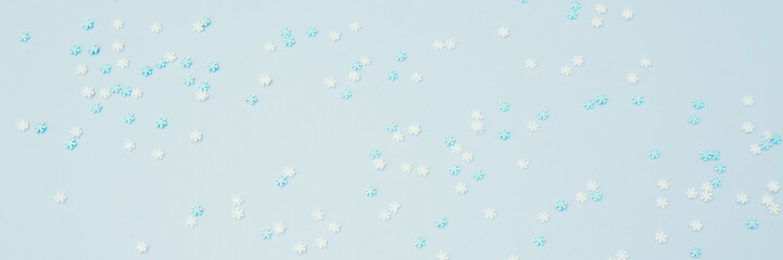 White and blue snowflakes sprinkles on blue. Festive holiday background. Celebration concept
