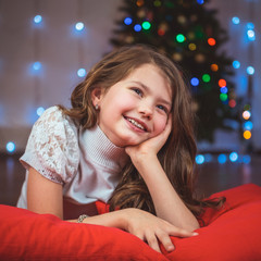 Portrait of a happy child with a gift on the background of a Christmas tree