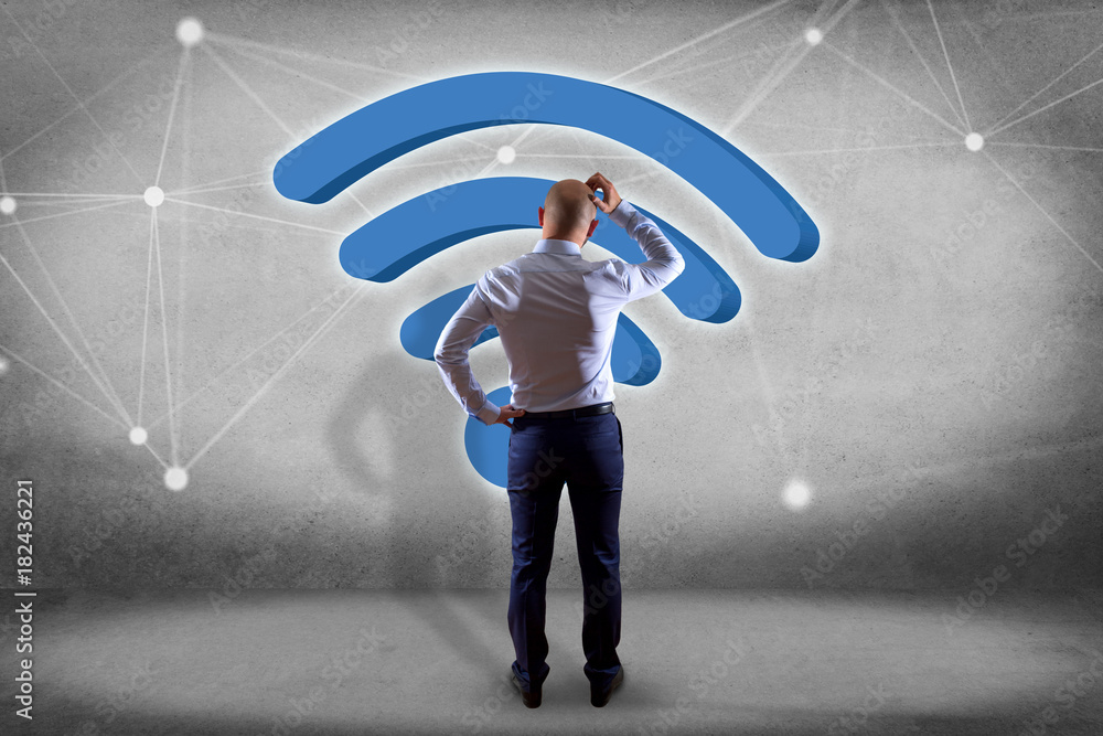 Poster businessman in front of a wall with wifi symbol displayed on a futuristic interface - connection and