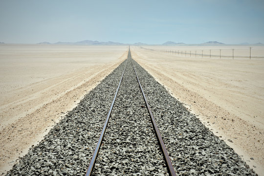 Railway tracks and endless row of electricity pylons in the desert close to Luderitz, Namibia, Africa