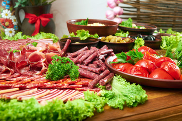Close up shot of smoked chopped sausages and salami slices on the meat plate at the local restaurant served with greens copyspace layout luxury eating appetite menu order.