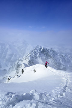 Female skier ascending on snowface to Piz Zuort, Switzerland 