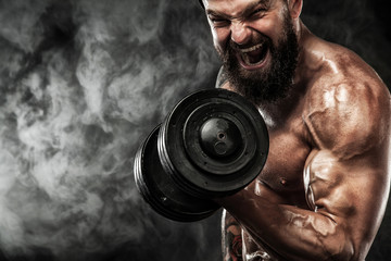 Muscular young fitness sports man workout with dumbbell in fitness gym