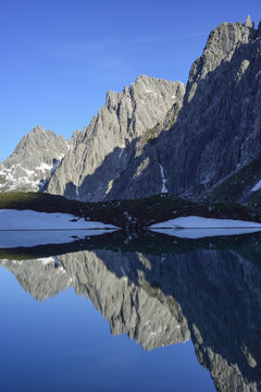 Reflection of Steinkarspitze in lake Steinsee, Lechtal Alps, Tyrol, Austria