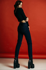 Fototapeta na wymiar beautiful brunette girl posing in studio on red background
