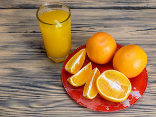oranges and orange juice on a wooden background
