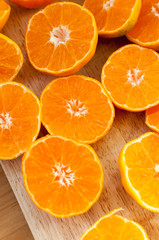 tangerines cut in half on a wooden board